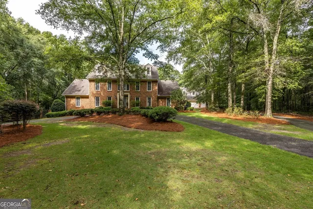 a view of a house with backyard and sitting area