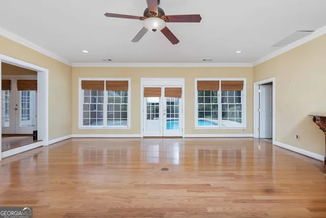 a view of a livingroom with wooden floor and a chandelier