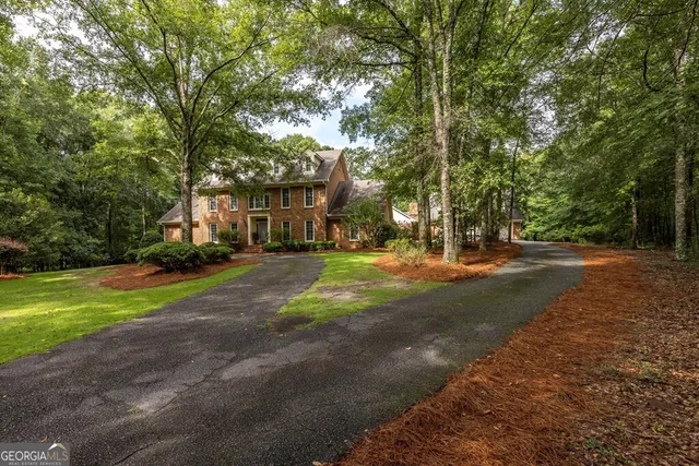 a front view of residential houses with yard and trees