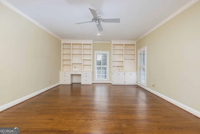 an empty room with windows and cabinet