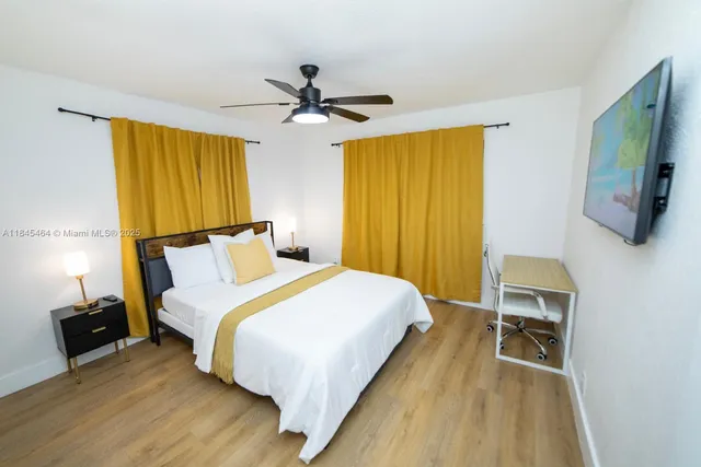 a bedroom with a bed and a flat tv screen on a dresser