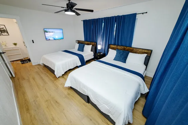 a bedroom with two beds and painting on the wall