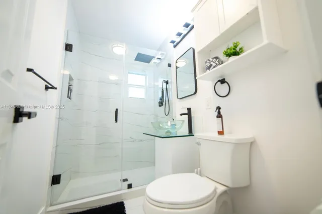 a bathroom with a toilet and a shower