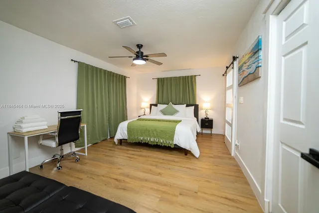 a bedroom with a large bed and a chandelier