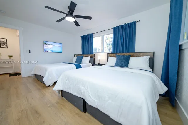 a spacious bedroom with two beds and a window