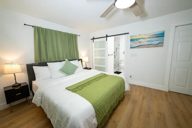 a bedroom with a bed and a painting on the wall