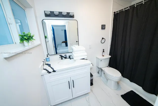a bathroom with a sink a toilet and mirror