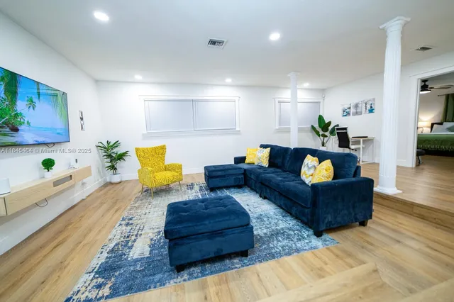 a living room with furniture and wooden floor