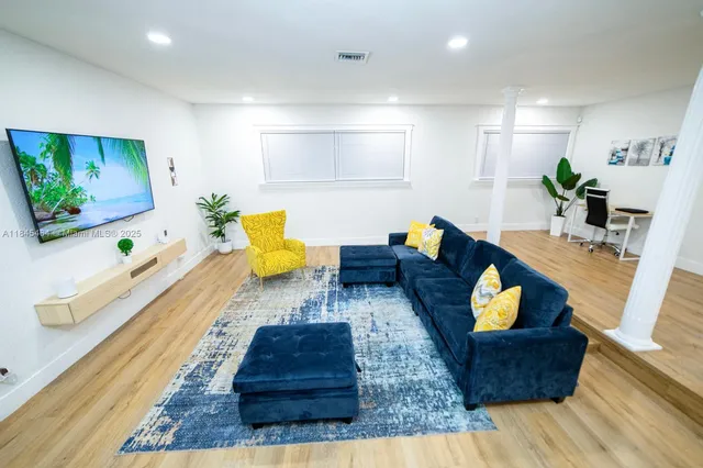a living room with furniture and wooden floor