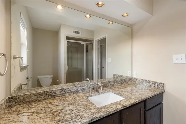 a bathroom with a granite countertop sink and a mirror