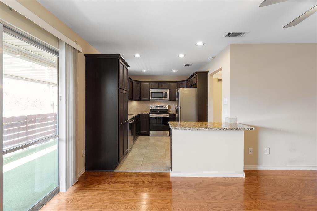 4709 Skillman Street, Unit D Dallas, TX 75206 - Photo 8 of 28 a view of a kitchen with kitchen island a counter top space cabinets and stainless steel appliances