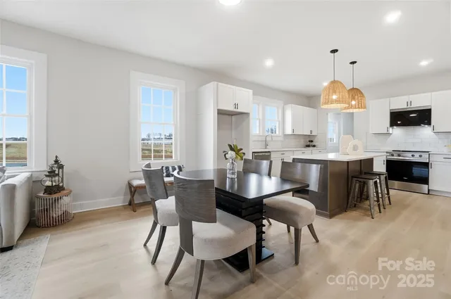 a kitchen with kitchen island a dining table and chairs