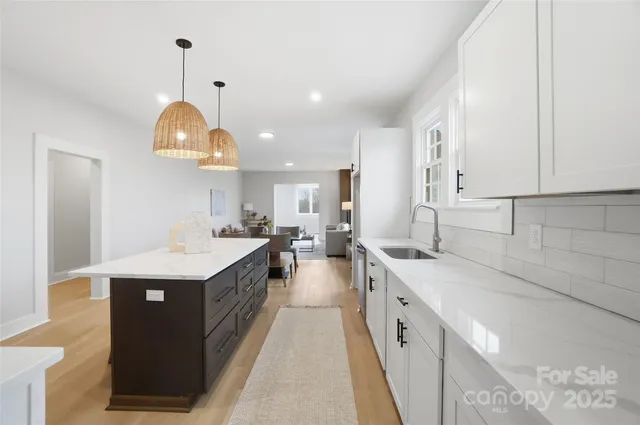 a large kitchen with kitchen island a sink a counter space and stainless steel appliances