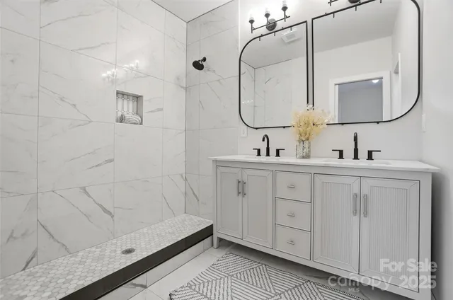 a bathroom with a double vanity sink a mirror and a shower