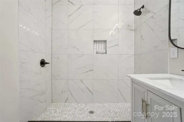 a bathroom with a sink shower and a mirror