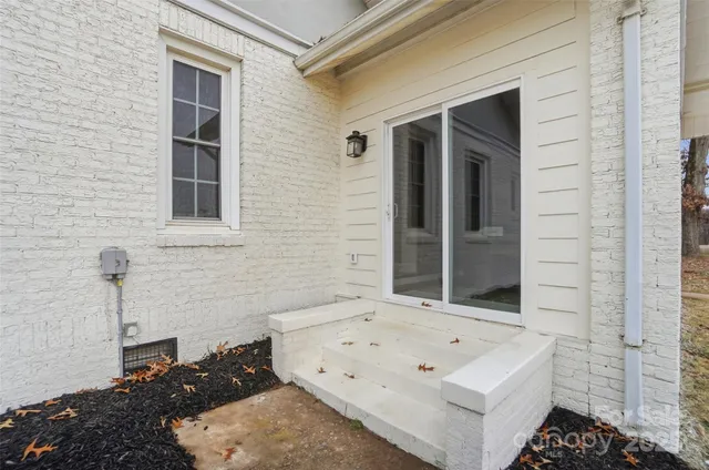 a view of a white house with a sink and a potted plant