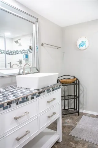 a bathroom with a granite countertop sink a mirror and shower