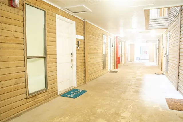 a view of a door with wooden floor and a bathroom