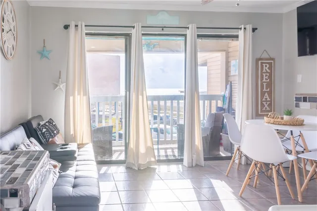a dining room with furniture and large windows