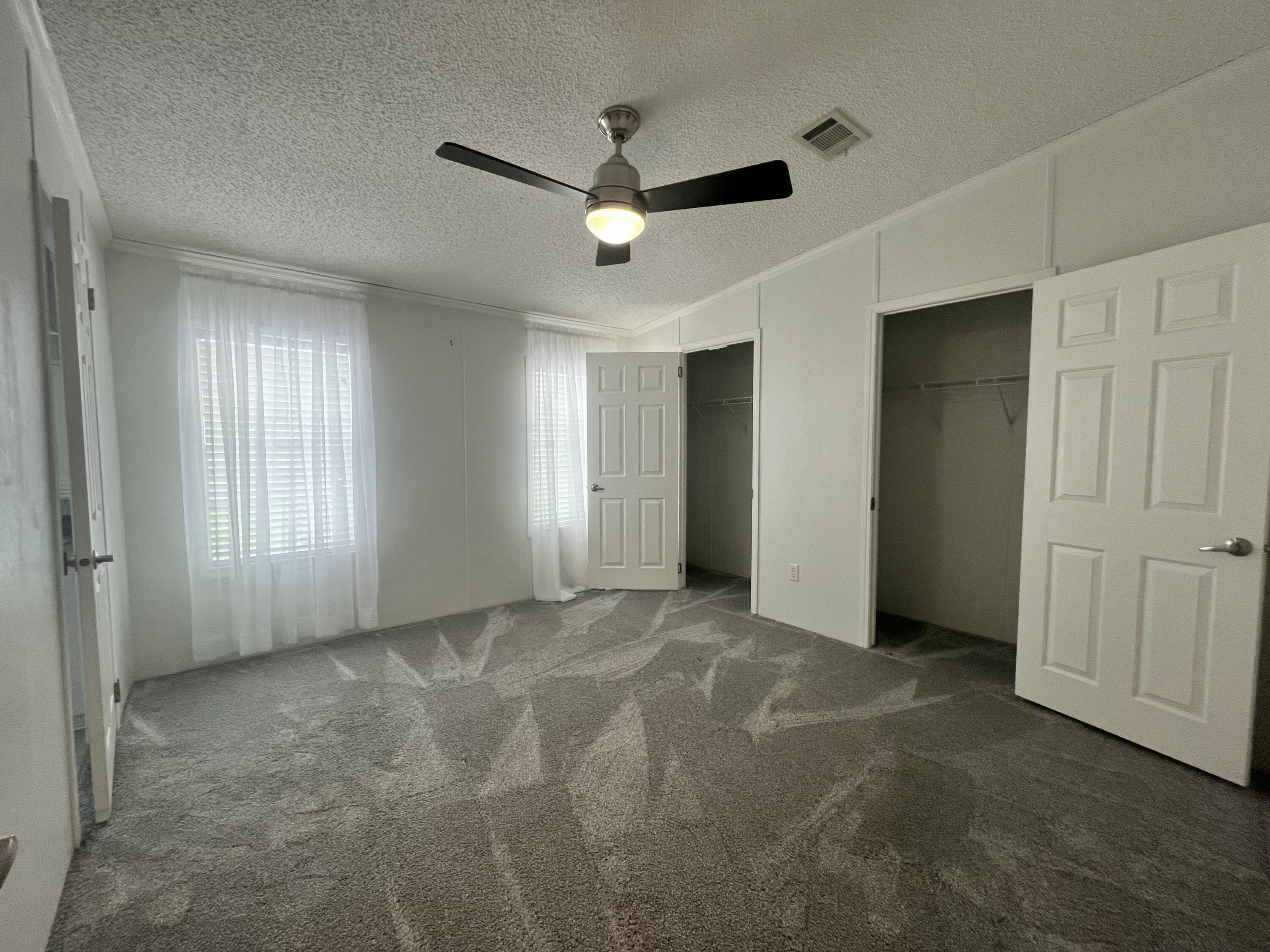 4064 Southwest 9th Way Okeechobee, FL 34974 - Photo 13 of 39 a view of a livingroom with a ceiling fan & windows
