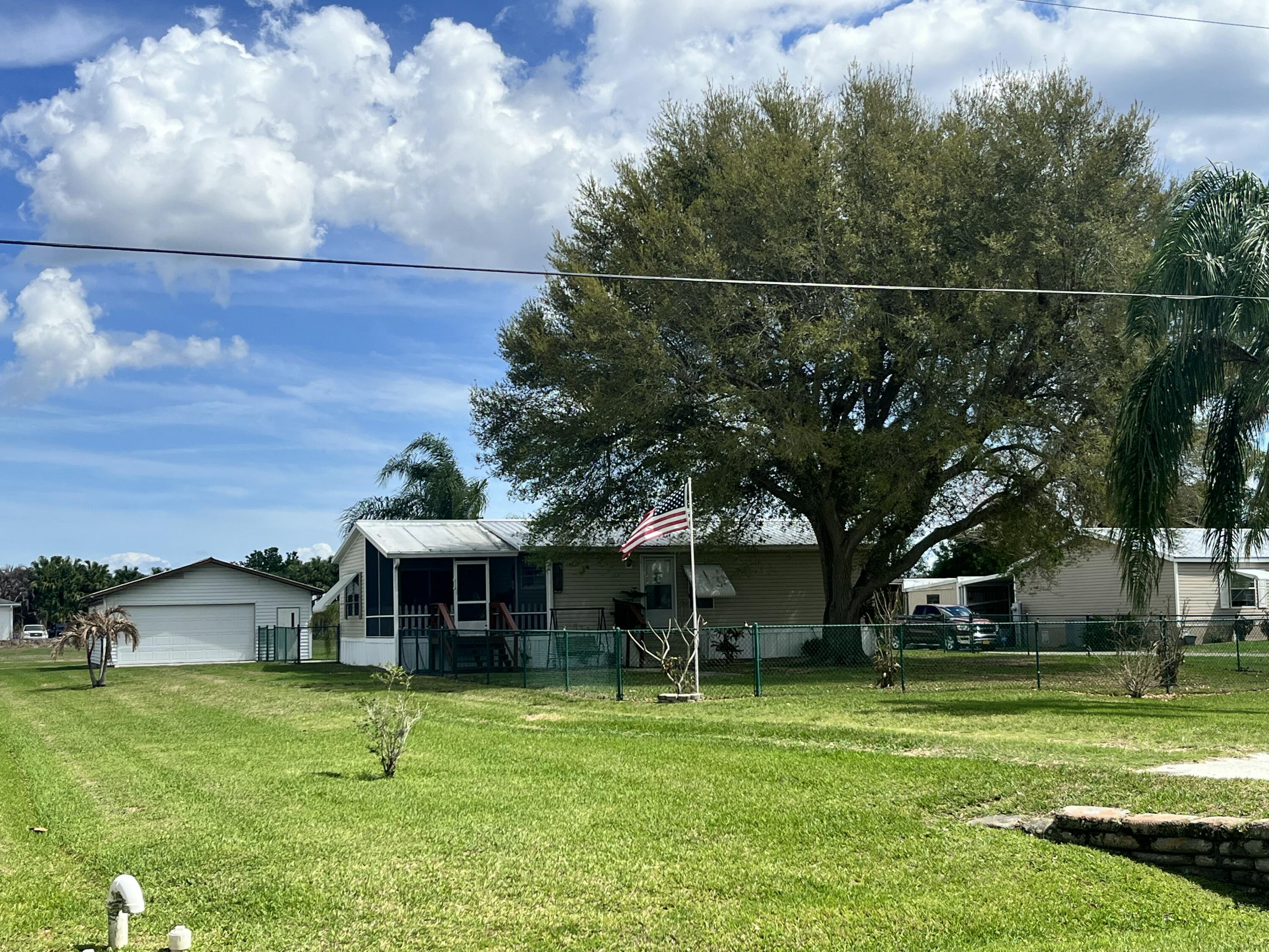 4064 Southwest 9th Way Okeechobee, FL 34974 - Photo 19 of 39 a front view of a house with a garden and trees