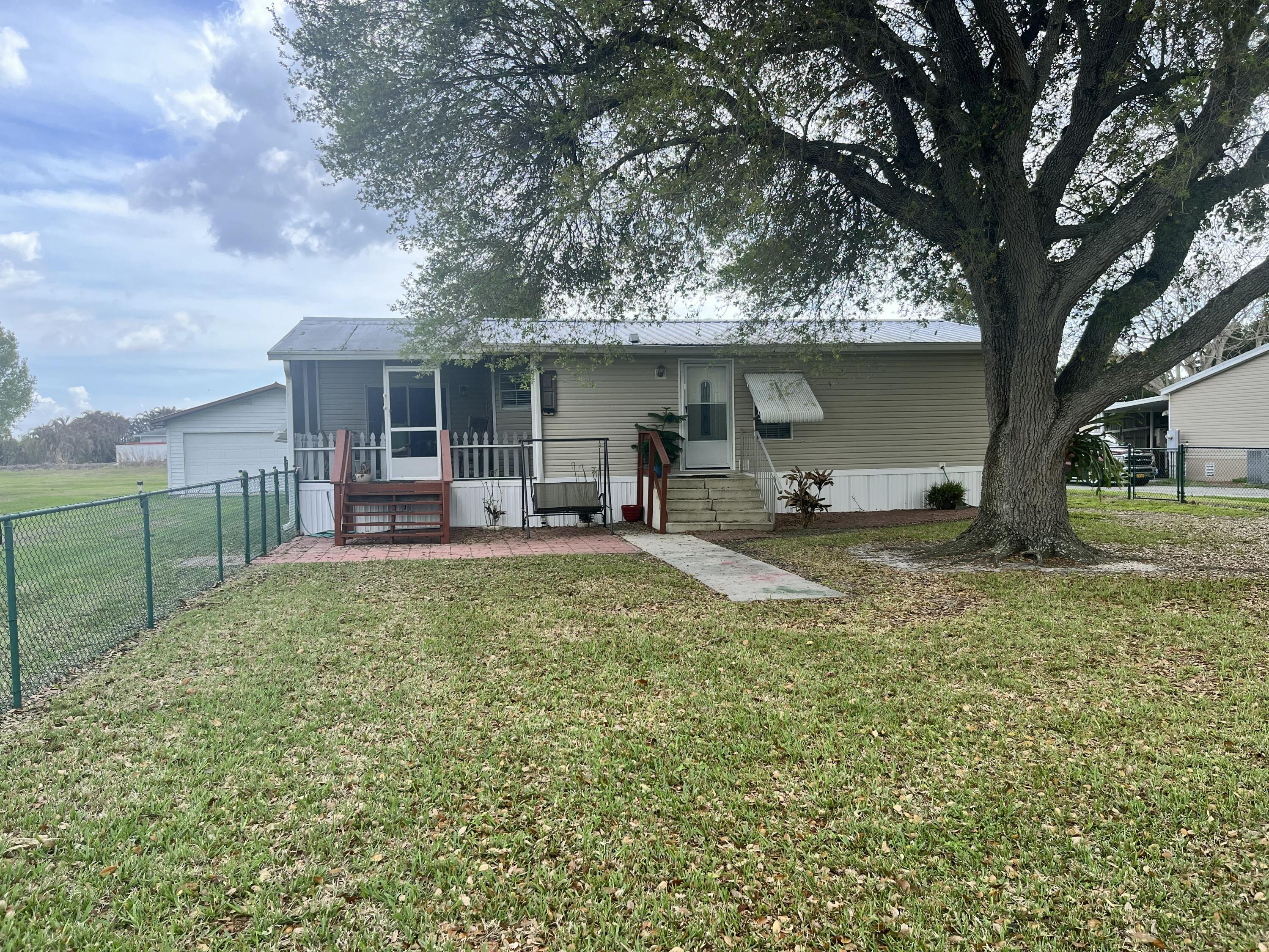 4064 Southwest 9th Way Okeechobee, FL 34974 - Photo 21 of 39 a view of a house with backyard and a tree