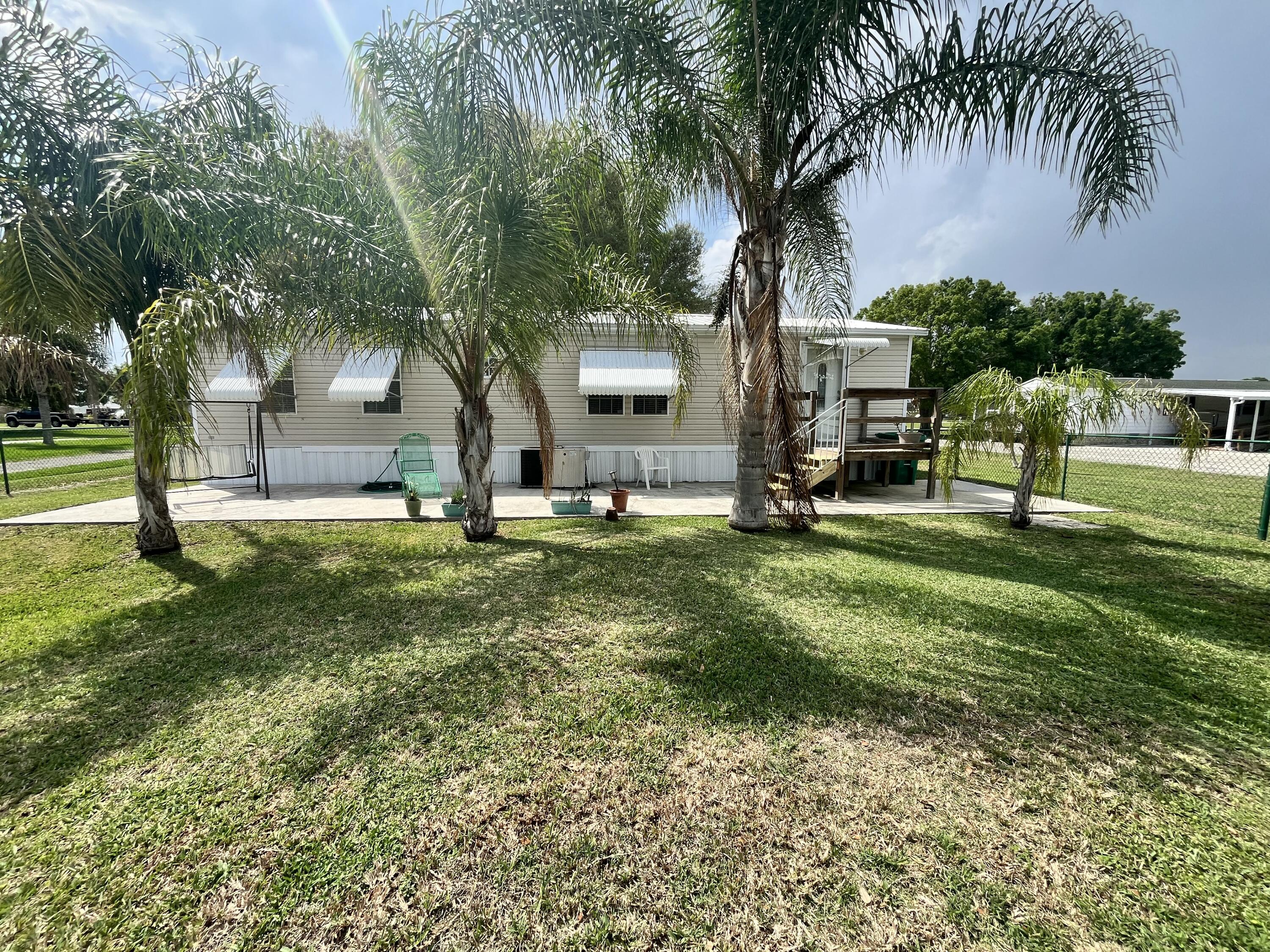 4064 Southwest 9th Way Okeechobee, FL 34974 - Photo 25 of 39 a front view of house with yard and green space