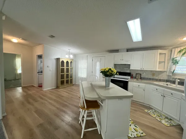 a kitchen with a table chairs refrigerator and microwave