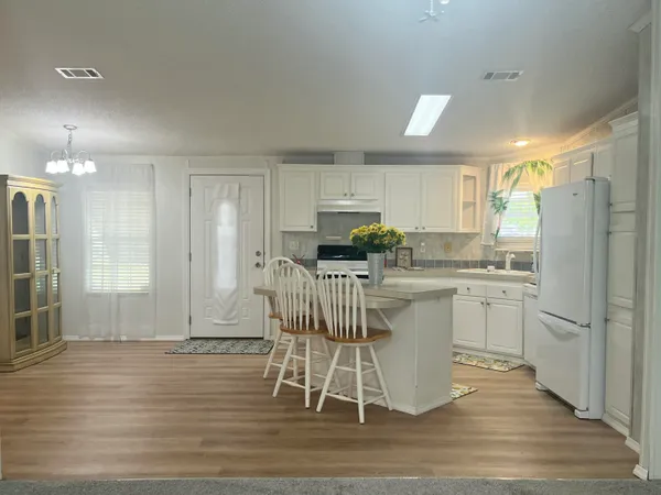 a kitchen with a refrigerator a sink and cabinets
