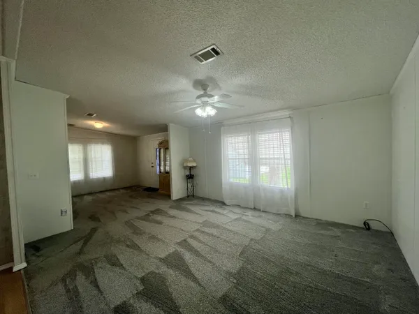 a view of a livingroom with a ceiling fan and window