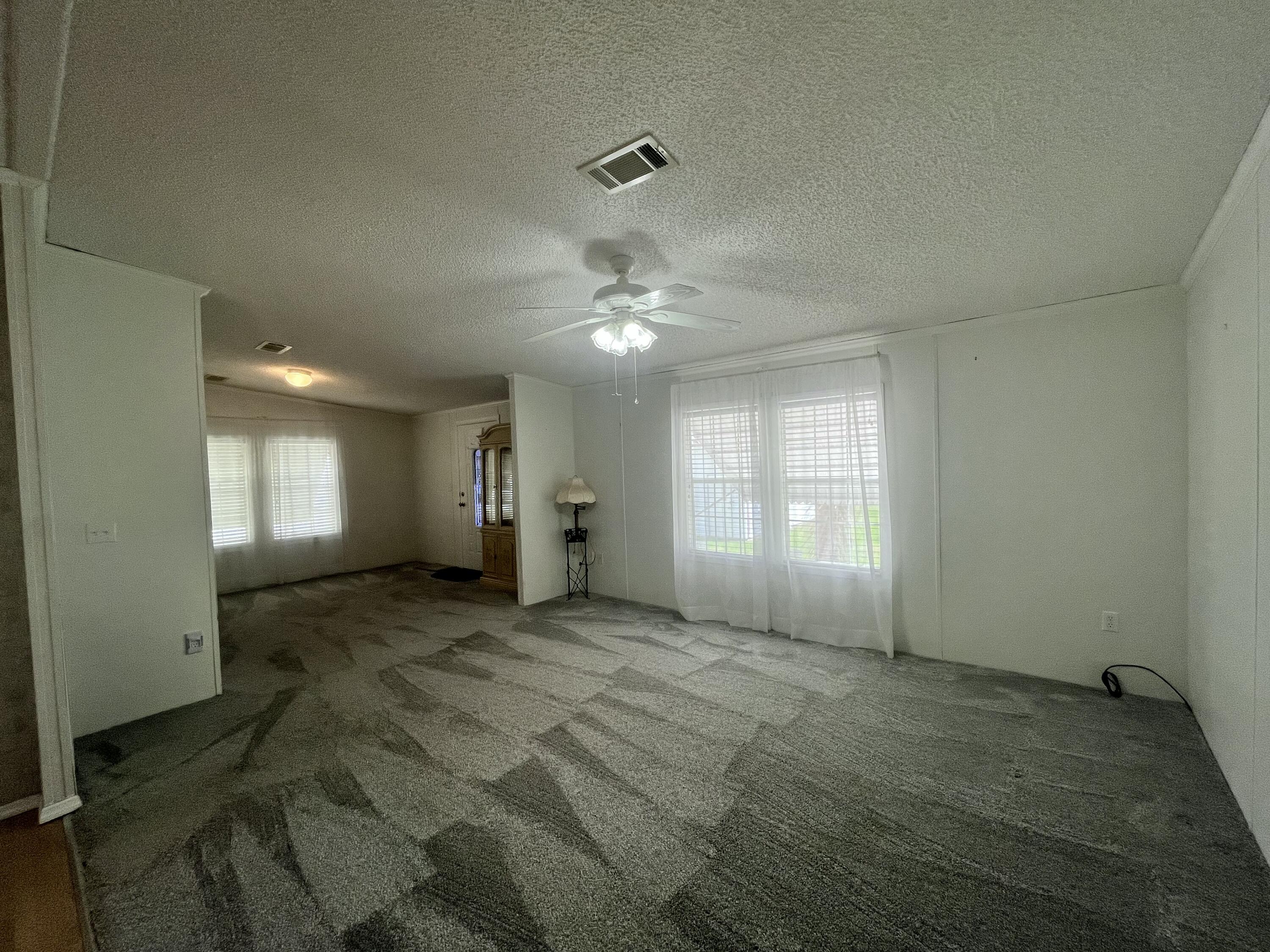 4064 Southwest 9th Way Okeechobee, FL 34974 - Photo 8 of 39 a view of a livingroom with a ceiling fan and window