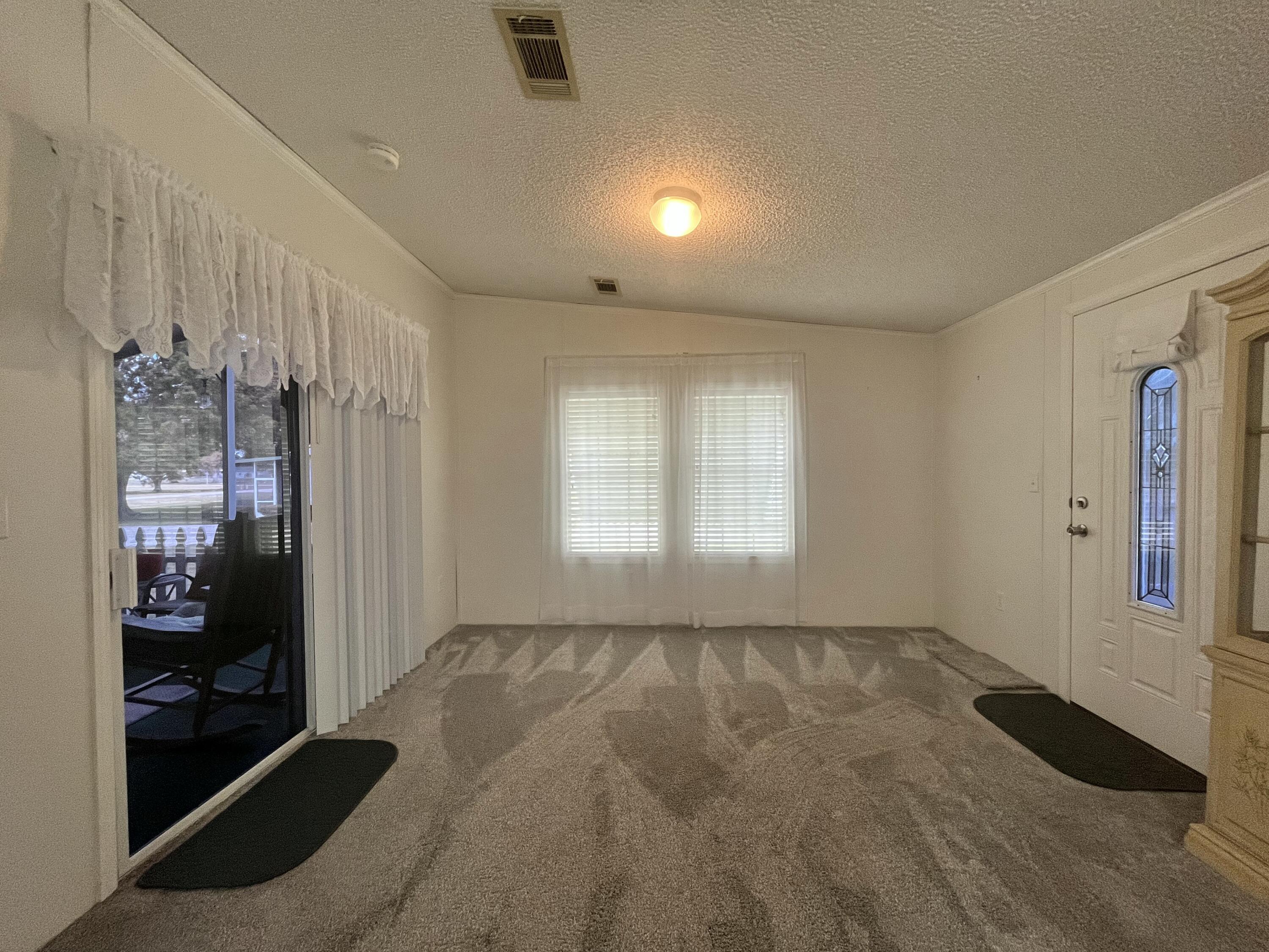 4064 Southwest 9th Way Okeechobee, FL 34974 - Photo 9 of 39 a view of an empty room with glass door