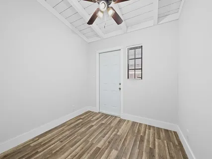 an empty room with a window and ceiling fan
