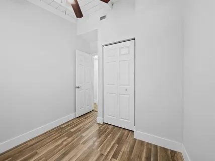 a view of an empty room with wooden floor