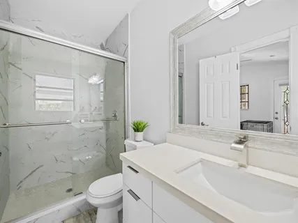 a bathroom with a sink toilet and shower