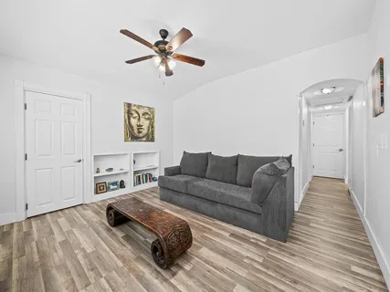 a living room with furniture and a wooden floor