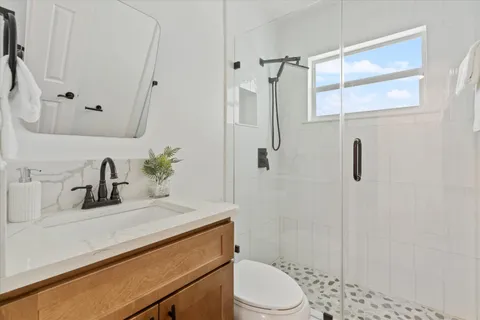 a bathroom with a sink a toilet and shower