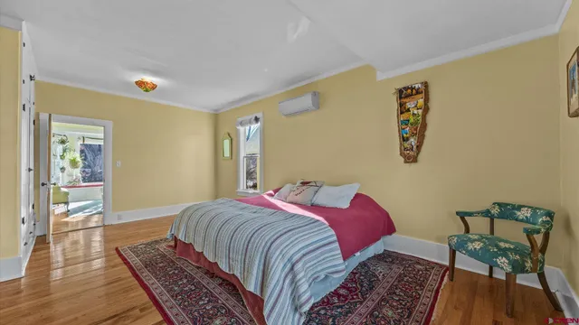 a spacious bedroom with a bed and wooden floor