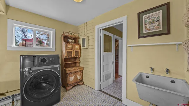 a view of a white house with a small yard and parking space