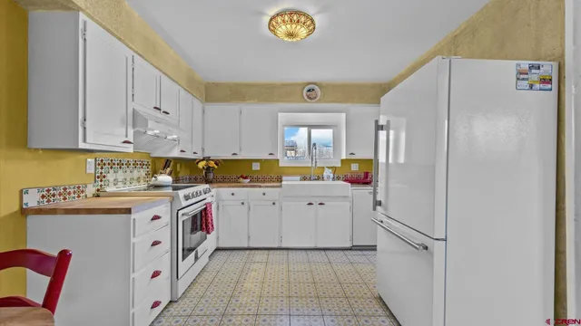 a white refrigerator freezer sitting inside of a kitchen