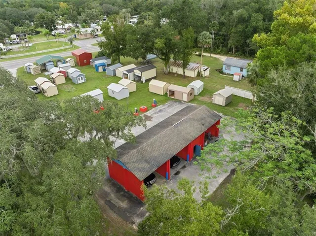 an aerial view of residential houses with outdoor space and trees