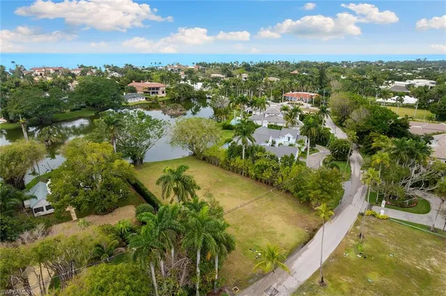 an aerial view of residential houses with outdoor space and trees