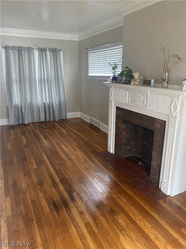 4688 Rockwood Road Cleveland, OH 44125 - Photo 17 of 35 Living room featuring crown molding, dark hardwood flooring, and a fireplace