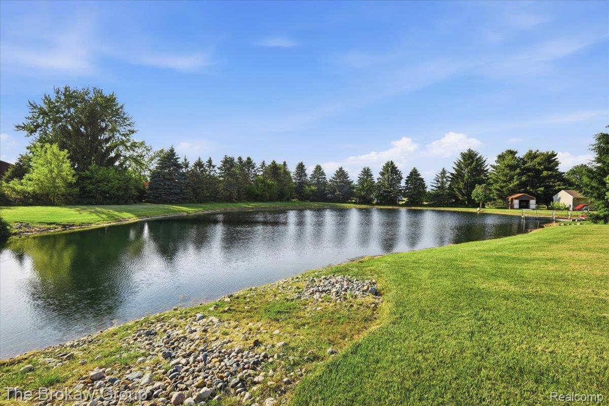 5461 North Henderson Road Davison, MI 48423 - Photo 9 of 64 Expansive pond featuring surrounding green lawn, mature perimeter trees, and a distant shed structure
