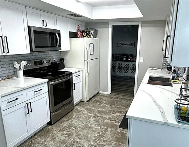 a kitchen with stainless steel appliances granite countertop a refrigerator stove and sink