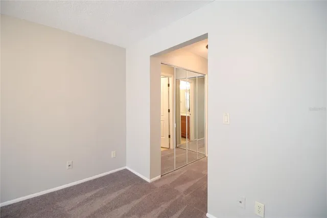 an empty room with wooden floor and a hallway