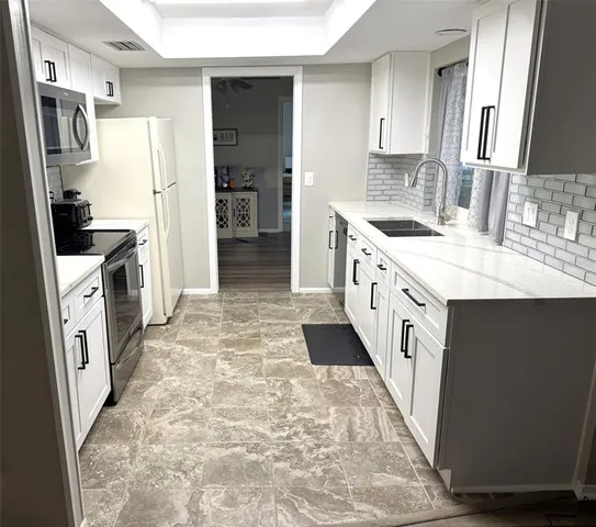 a large kitchen with a stove a refrigerator a sink a oven and a refrigerator