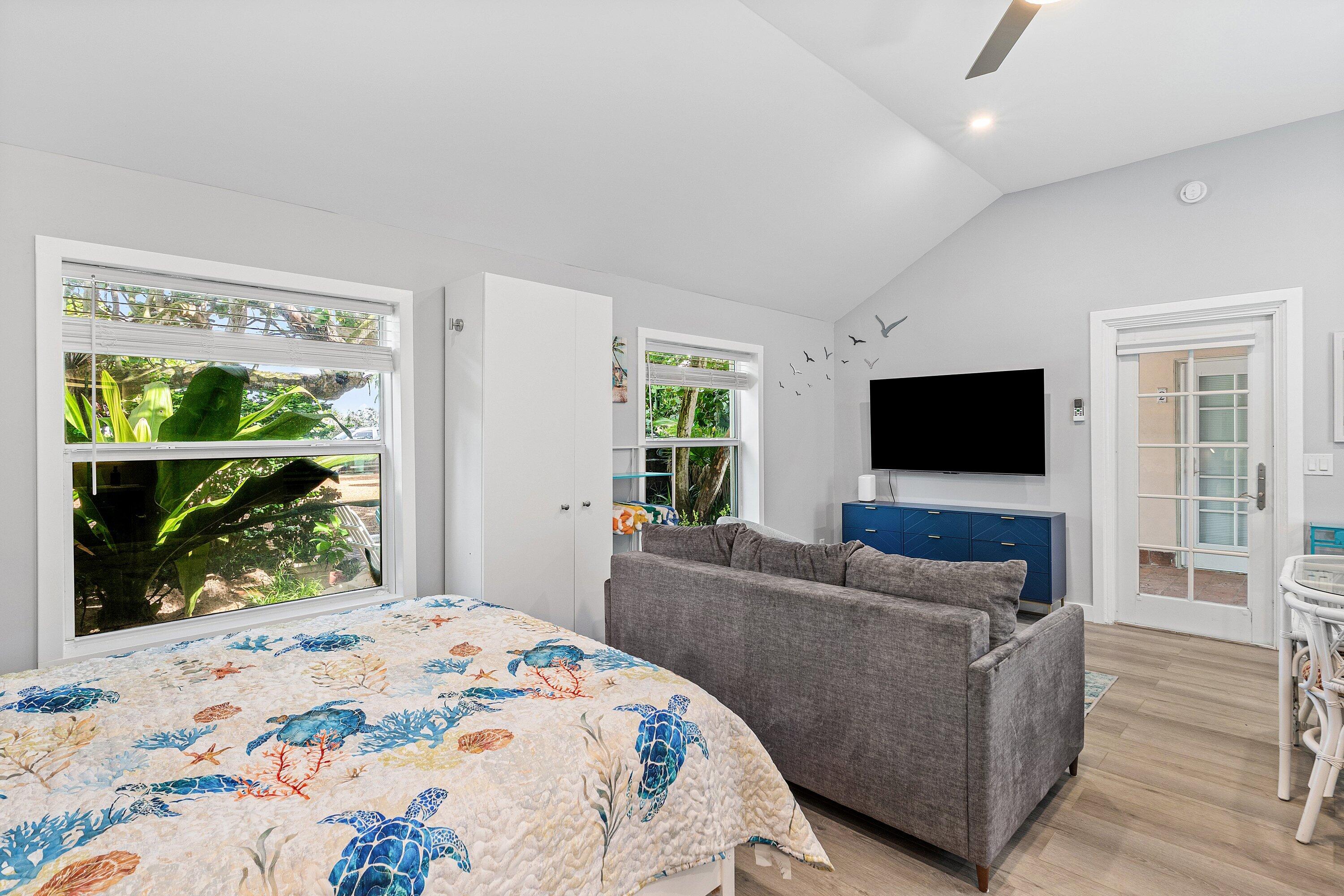 72 South Ocean Boulevard, Unit 1 Delray Beach, FL 33483 - Photo 15 of 35 a bedroom with furniture and a flat screen tv
