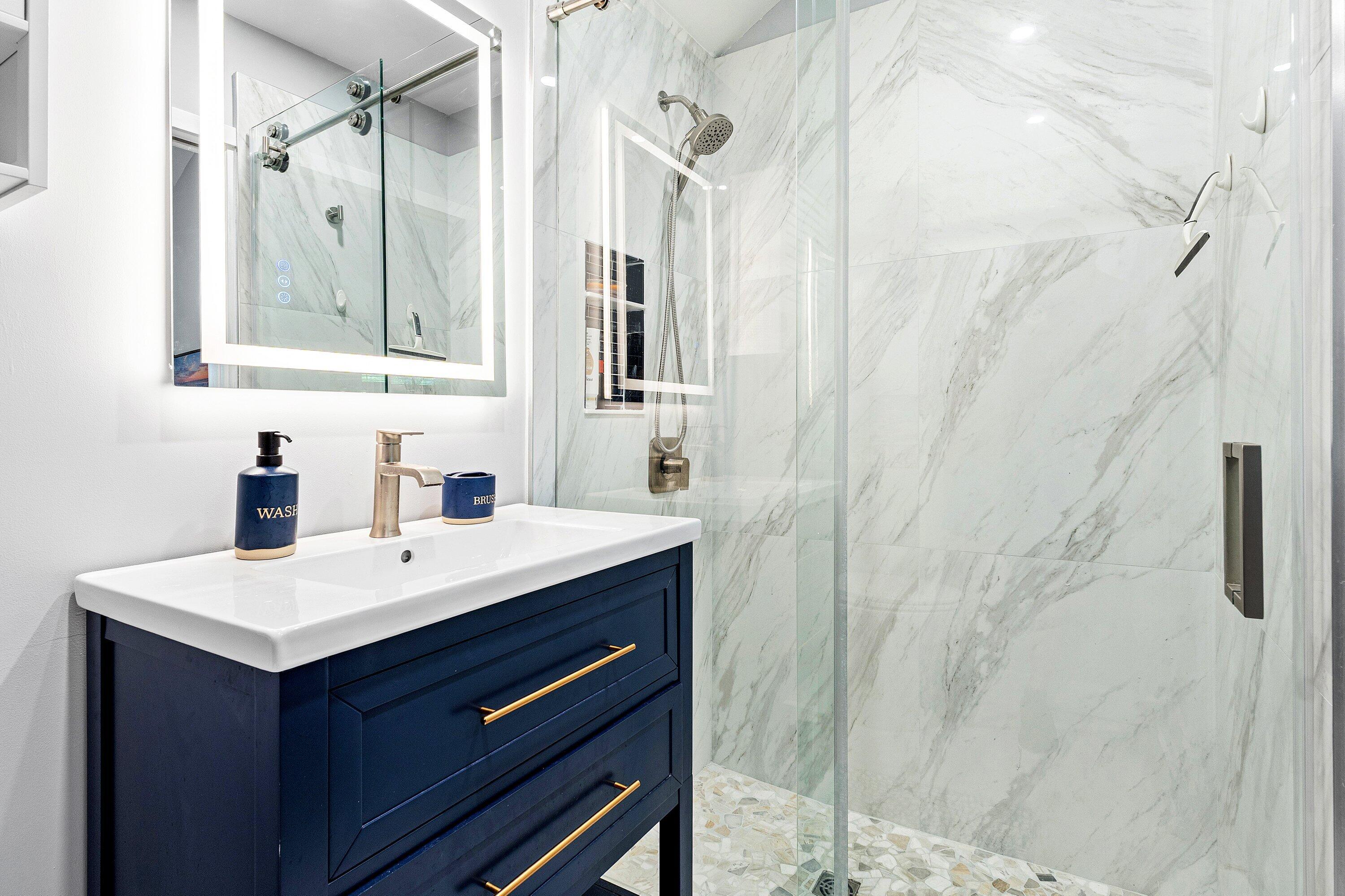 72 South Ocean Boulevard, Unit 1 Delray Beach, FL 33483 - Photo 18 of 35 a bathroom with a sink a mirror a vanity and shower