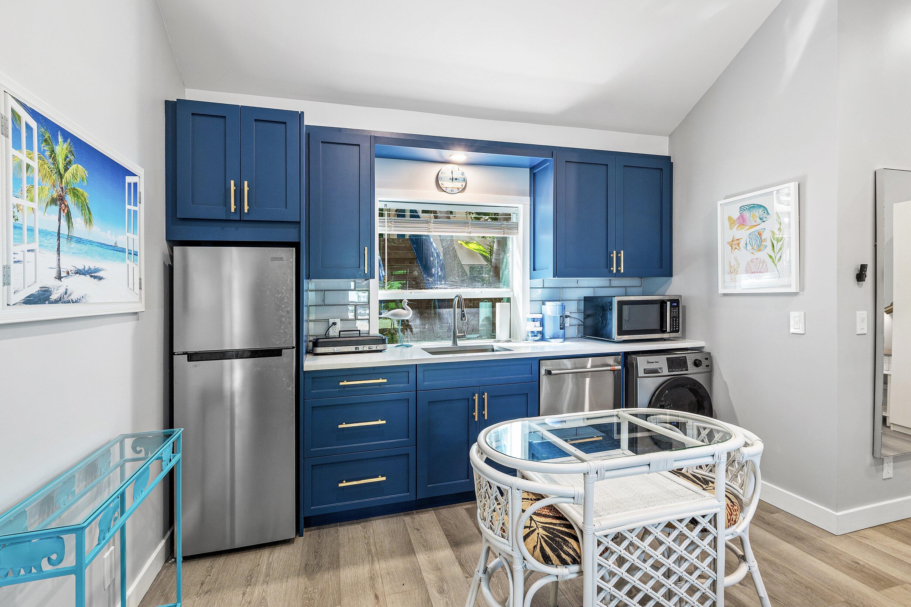72 South Ocean Boulevard, Unit 1 Delray Beach, FL 33483 - Photo 9 of 35 a kitchen with a refrigerator sink and wooden cabinets